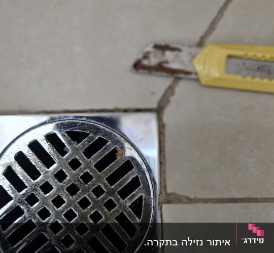 תמונה של ניקוז וכלי עבודה על רצפה